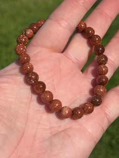 This sparkling bracelet is made with gorgeous goldstone beads. Each bead shimmers elegantly as the bracelet moves in the light. Intentions of joy, grounding, and self-reflection pair well with goldstone jewelry. The bracelet is double strung for durability, stretches for your comfort, and stacks nicely with other bracelets. Goldstone (also called sandstone) is a stone of ambition and joy. It is a type of glass and has reflective properties to help you see your authentic self more clearly. Goldstone is a very warm stone, encouraging you to fill your cup while simultaneously grounding you. *Information for metaphysical purposes only - Goldstone beads, ~7.6-7.9mm *Note: Goldstone is a man-made stone. - Beading string Items are packed with care and sent straight to your door. Thank you for vis Sparkling Beaded Bracelets For Gifts, Sparkling Adjustable Beaded Bracelets As Gift, Adjustable Sparkling Beaded Bracelets As Gift, Sparkling Round Bead Bracelets For Gifts, Sparkling Round Beads Crystal Bracelet As Gift, Sparkling Round Beads Crystal Bracelet For Gift, Sparkling Beaded Bracelets As Gift, Adjustable Sparkling Beaded Bracelet For Gift, Sparkling Crystal Bracelet With Round Beads For Gift