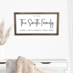 a white table with a chair and a sign on the wall above it that says, the smith family