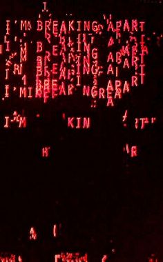 the words are written in red and black on a screen with dark lighting behind them