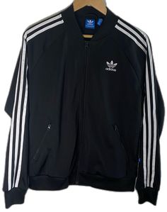 Black Track Jacket For Streetwear In Spring, Black Track Jacket For Spring Streetwear, Sporty Black Outerwear For Spring, Sporty Black Spring Outerwear, Adidas Black Track Jacket For Winter, Fitted Black Track Jacket With Ribbed Cuffs, Black Long Sleeve Track Jacket For Spring, Adidas Black Track Jacket For Spring, Adidas Track Jacket With Ribbed Cuffs For Fall