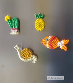 three different types of bead designs on a table top, one with a fish and the other with a pineapple