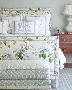 a bed with blue and white flowers on it