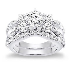 a white gold engagement ring set with two round diamonds on the shoulders and an intricate band