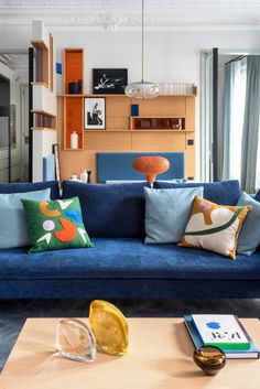 a living room filled with blue couches and pillows on top of a wooden table