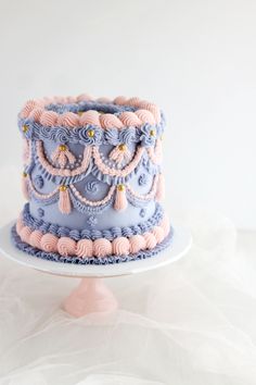 a blue and pink cake sitting on top of a white plate