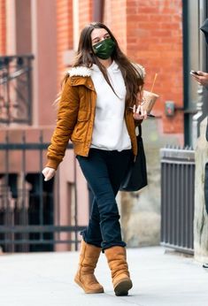 a woman walking down the street wearing a mask