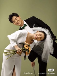 a man and woman posing for a photo with flowers in front of their faces on a green background