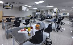 an empty cafeteria with tables and chairs in the center, food trays on the table