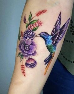 a colorful hummingbird with flowers on its arm