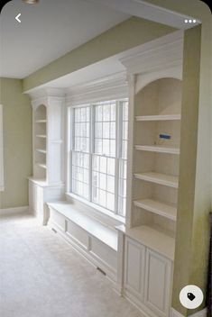 an empty living room with built in bookshelves