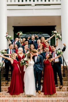 a group of people in formal wear standing on steps with their arms up and hands in the air