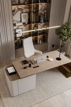 an office desk with a laptop and phone on it in front of a bookcase