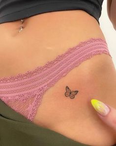 a woman's stomach with a small butterfly tattoo on her left side ribcage