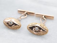 These cufflinks, circa the late 1800s, are the very definition of sophistication. The warm antique gold radiates with a warm and inviting luster. The cufflinks are decorated with a curling, curving scalloped motif, giving the old mine-cut diamonds the perfect backdrop to sparkle. What a wonderful wedding gift these will make!Metal: 10K Antique Rose Gold, 14K Yellow Gold Gem: 2 Old Mine Cut Diamonds totaling .12 Carats, VS in Clarity, G-H in ColorGem Measurements: 2.2 mm, RoundMeasurements: 18 x 10 mm Antique Yellow Gold Formal Cufflinks, Antique Gold Cufflinks For Collectors, Vintage Yellow Gold Cufflinks For Wedding, Antique Yellow Gold Cufflinks For Formal Occasions, Antique Engraved Cufflinks For Formal Occasions, Antique Engraved Cufflinks For Formal Wear, Vintage Engraved Cufflinks For Anniversary, Antique Gold Cufflinks, Vintage Yellow Gold Cufflinks With Polished Finish