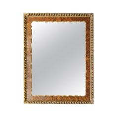 a mirror that is sitting on top of a white wall with an ornate border around it