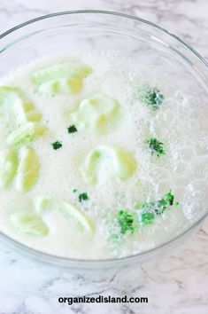 a glass bowl filled with liquid and some type of food on top of a marble counter