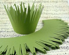 a green paper crown sitting on top of sheet music