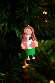 a christmas ornament hanging from a tree with the flag of mexico on it