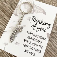 a card with a keychain that says, thinking of you butterflies hover and feathers appear whenever lost ones are near