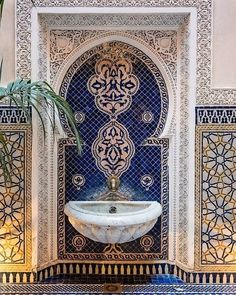 an ornate fountain in the middle of a room with blue and gold tiles on it