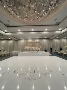 an empty ballroom with chandeliers and tables