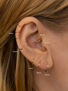 a woman's ear with three different types of piercings