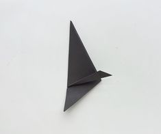 a black origami bird sitting on top of a white table