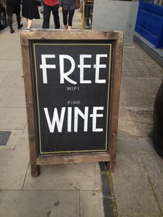 a free wifi wine sign on the sidewalk