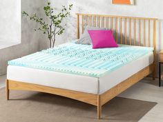 a bed with a wooden headboard and foot board in a room next to a potted plant