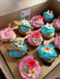 cupcakes with pink, blue and white frosting in a box