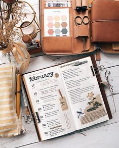 an open book sitting on top of a wooden table next to a purse and other items