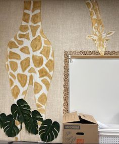 a giraffe is standing next to a mirror and some plants