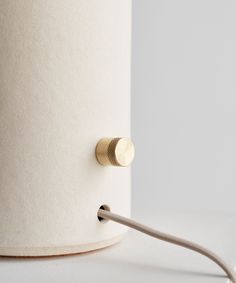 a close up of a white lamp with a gold plated light fixture on it