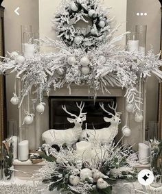 a fireplace decorated for christmas with white and silver decorations