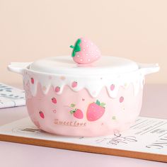 a pink ceramic bowl with a strawberry on top