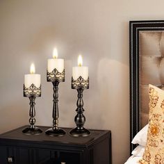 three lit candles are sitting on a night stand