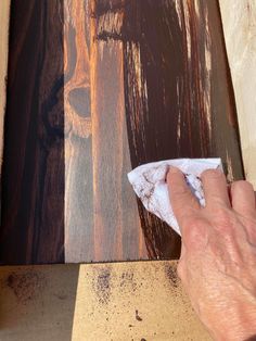 a person wiping down some wood with a cloth