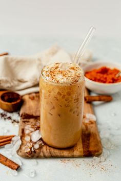 there is a drink on the table with cinnamons and spices around it to be used as garnishes