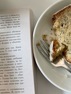 a piece of cake sitting on top of a white plate next to an open book