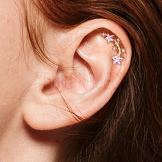 a woman's ear with three stars on it