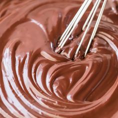 the chocolate is being stirred by two whisks