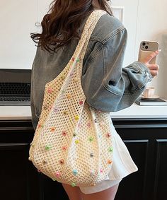 a woman is taking a selfie with her cell phone while wearing a white purse