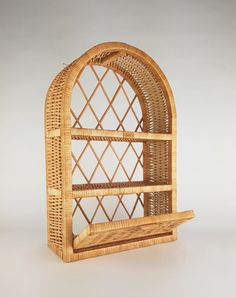 a wicker book shelf with an arched window on the top and bottom, made out of bamboo