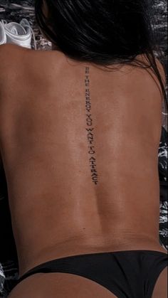 the back of a woman's body with writing on it