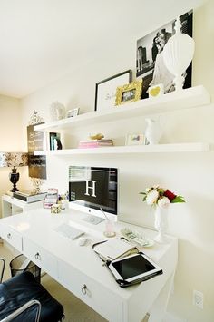 a white desk with a laptop computer on top of it next to a black chair