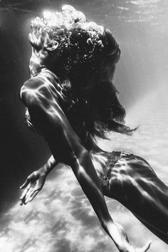 black and white photograph of a woman in the water with her back turned to the camera