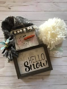 a snowman with a hat and scarf next to a sign that says hello snow