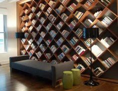 a living room filled with furniture and bookshelves next to a wall mounted book shelf