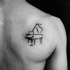 a black and white photo of a man's chest with a piano tattoo on it