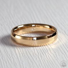 two gold wedding bands sitting on top of each other